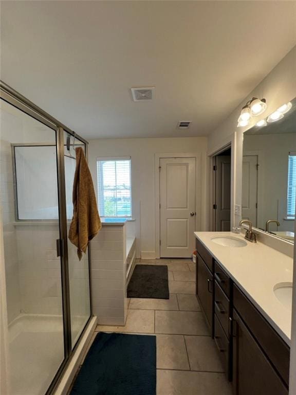 full bathroom featuring a sink, tile patterned flooring, a wealth of natural light, and a stall shower