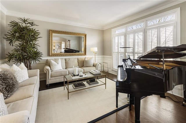 living area with a wainscoted wall, crown molding, a decorative wall, and wood finished floors