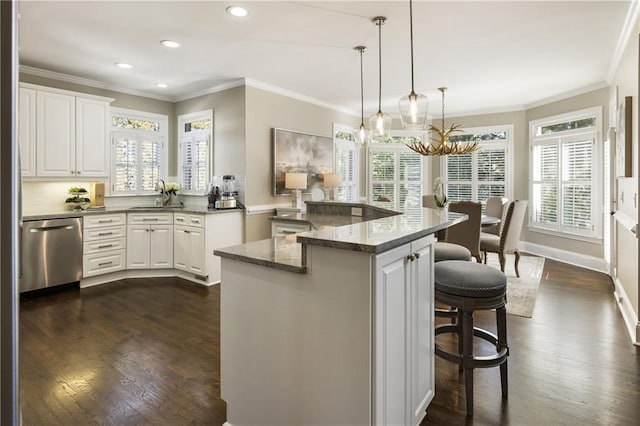 kitchen featuring dark wood-style flooring, a breakfast bar area, stainless steel dishwasher, ornamental molding, and a sink