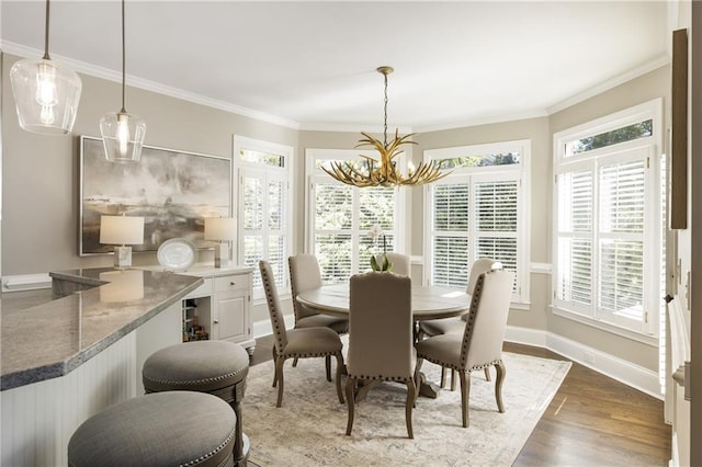 dining room featuring crown molding, baseboards, wood finished floors, and a healthy amount of sunlight