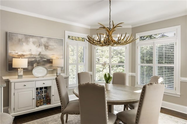 dining room with baseboards, ornamental molding, dark wood finished floors, and an inviting chandelier