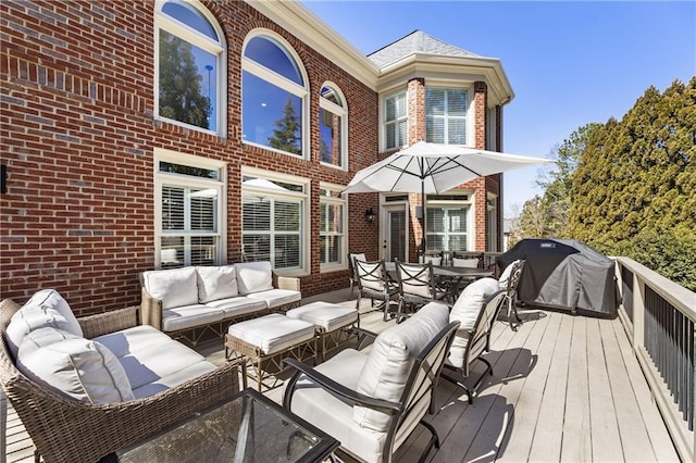 wooden deck with an outdoor hangout area and area for grilling