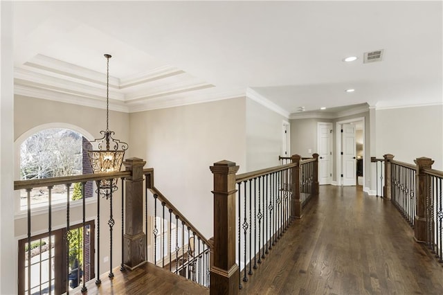 hall with wood finished floors, an upstairs landing, and an inviting chandelier