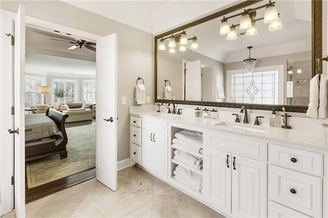 ensuite bathroom featuring ceiling fan with notable chandelier, a sink, ensuite bath, and double vanity