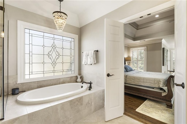 bathroom with a bath, wood finished floors, ensuite bathroom, crown molding, and a notable chandelier