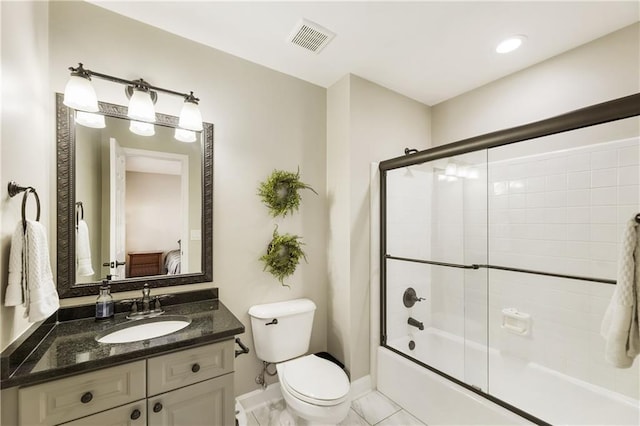 bathroom with enclosed tub / shower combo, toilet, vanity, baseboards, and visible vents