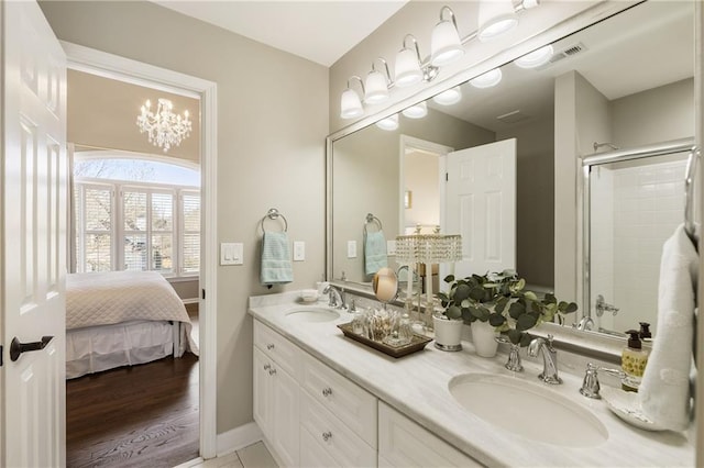 bathroom featuring double vanity, an enclosed shower, a sink, and visible vents