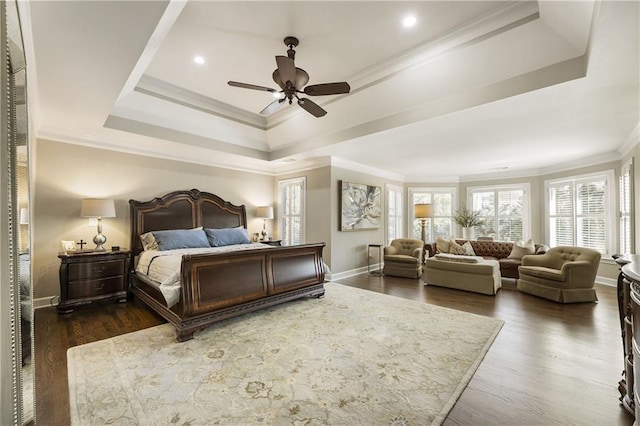 bedroom with baseboards, a tray ceiling, dark wood finished floors, and crown molding