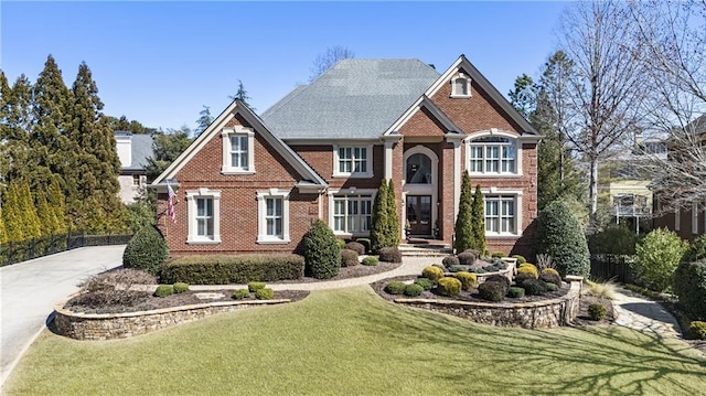 view of front facade with brick siding and a front yard