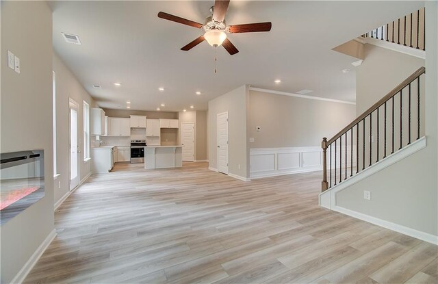 unfurnished living room with light wood-type flooring and ceiling fan