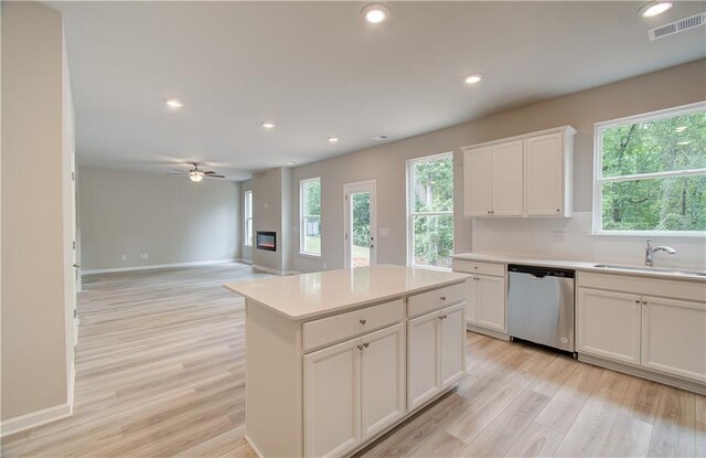 kitchen featuring a healthy amount of sunlight, white cabinets, sink, and dishwasher