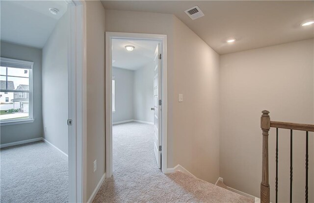 hall with light colored carpet