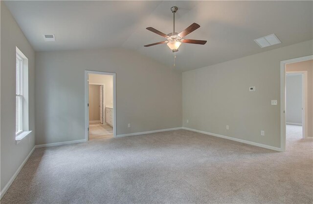 spare room with ceiling fan, lofted ceiling, and light carpet