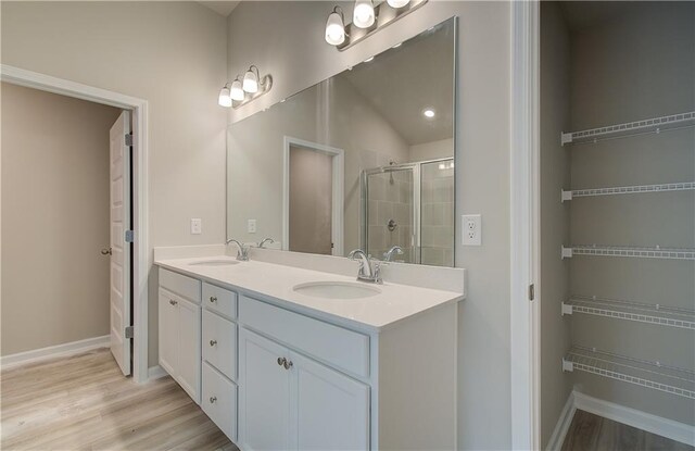 bathroom featuring a shower with door, hardwood / wood-style flooring, and vanity