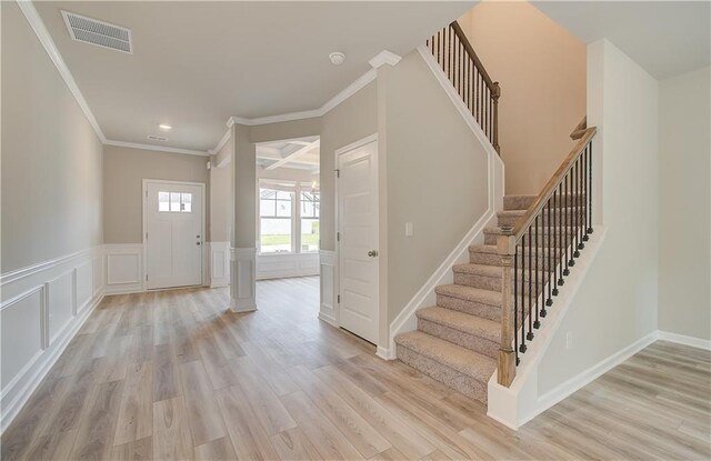 entrance foyer with crown molding and light hardwood / wood-style floors