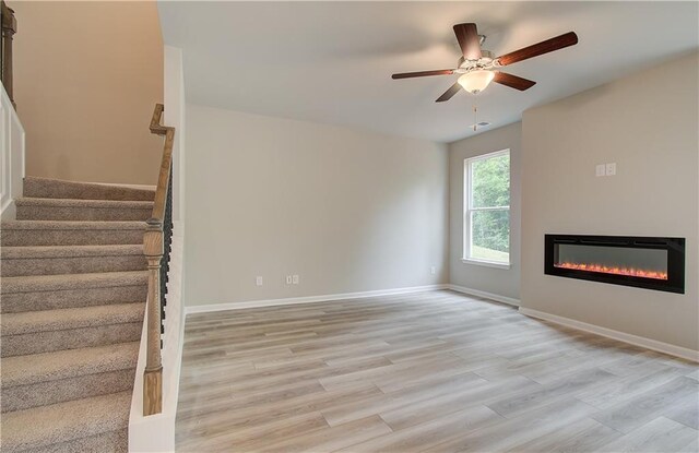 unfurnished living room featuring light hardwood / wood-style flooring and ceiling fan