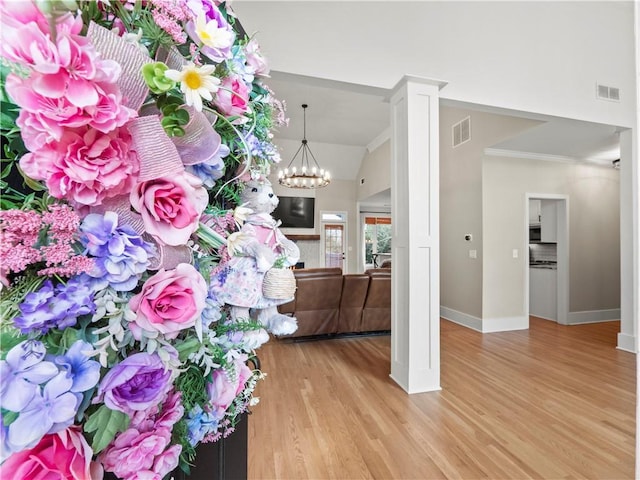 interior space with visible vents, a notable chandelier, baseboards, and wood finished floors