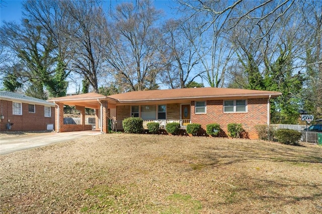 single story home featuring driveway, fence, a front lawn, and a carport