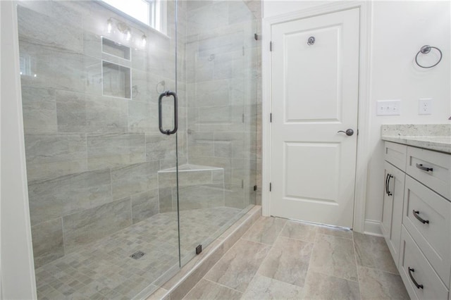 bathroom featuring tile patterned floors, vanity, and walk in shower