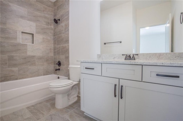 full bathroom featuring tile patterned flooring, toilet, tiled shower / bath combo, and vanity