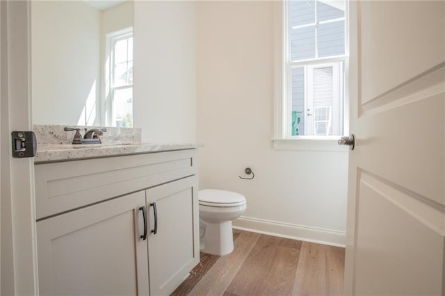 bathroom with wood-type flooring, toilet, and vanity