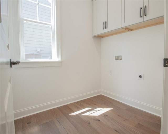 laundry area with hardwood / wood-style flooring, electric dryer hookup, hookup for a washing machine, and cabinets