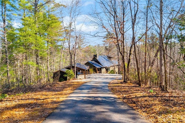 view of street with a view of trees and driveway