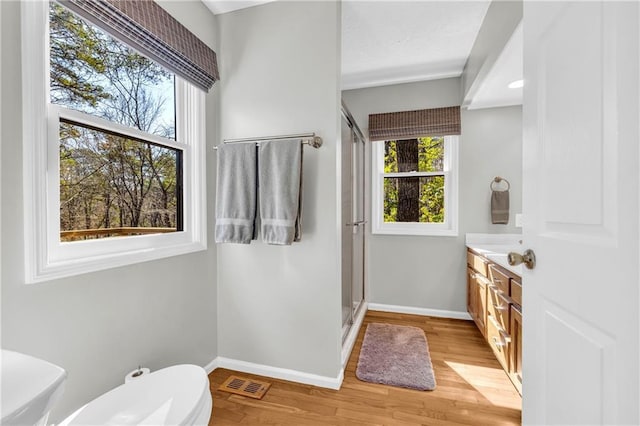 full bath with a wealth of natural light, visible vents, and wood finished floors