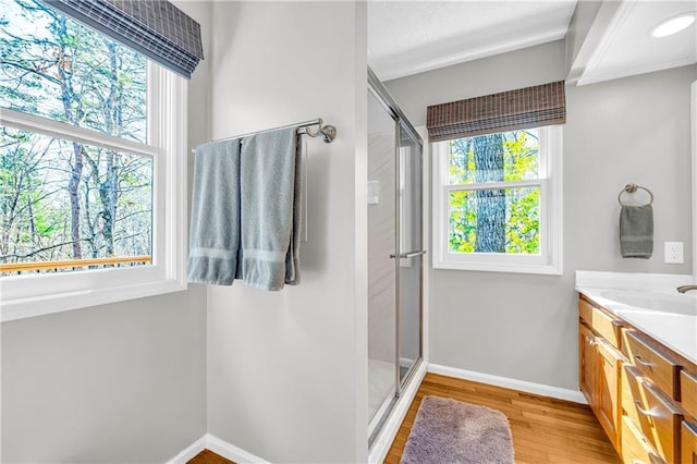 full bath featuring a stall shower, baseboards, wood finished floors, and vanity