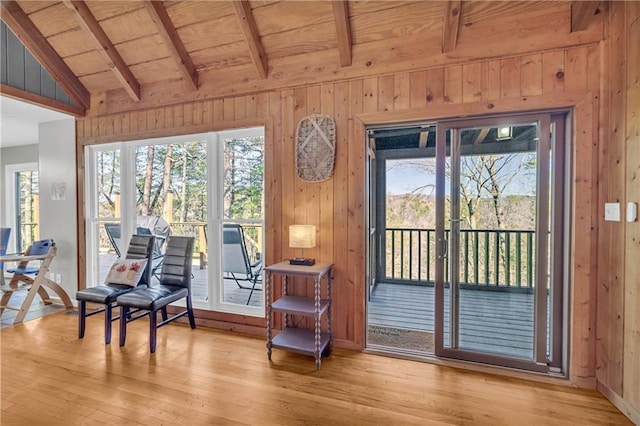 sitting room with wood ceiling, wood finished floors, vaulted ceiling with beams, and wood walls