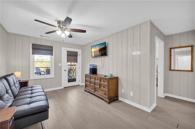 living room with wood finished floors, a ceiling fan, visible vents, and baseboards