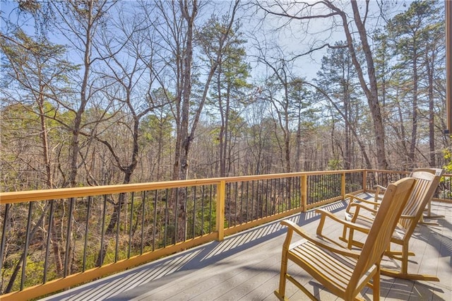 wooden terrace featuring a view of trees