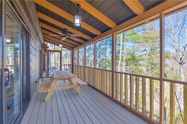 unfurnished sunroom featuring lofted ceiling with beams and a ceiling fan