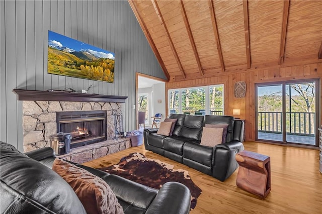 living area featuring a stone fireplace, wood finished floors, wooden ceiling, and wood walls