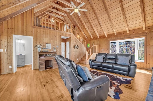 living room with wood ceiling, wood walls, light wood-type flooring, and stairs