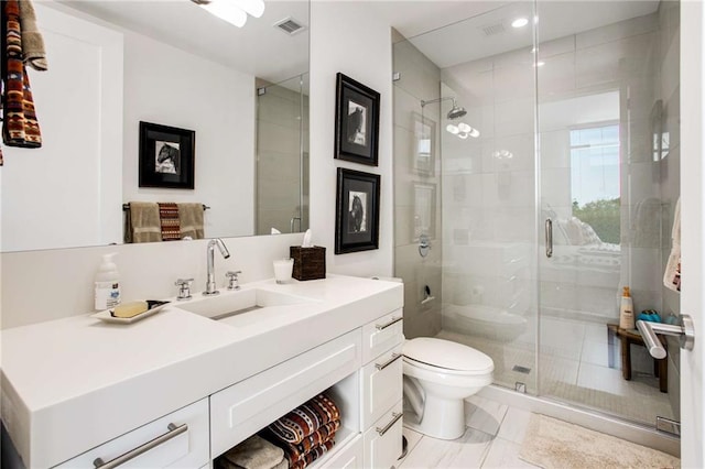 bathroom with vanity, toilet, and a shower with shower door