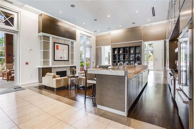 kitchen with a large island, a healthy amount of sunlight, and light tile patterned flooring