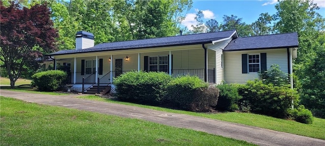 ranch-style house featuring a front lawn, a chimney, and a porch