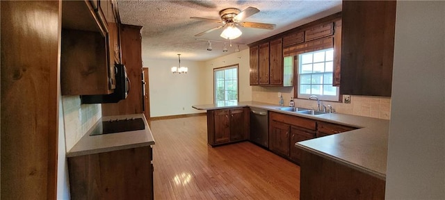 kitchen featuring a peninsula, dishwasher, a sink, a ceiling fan, and backsplash