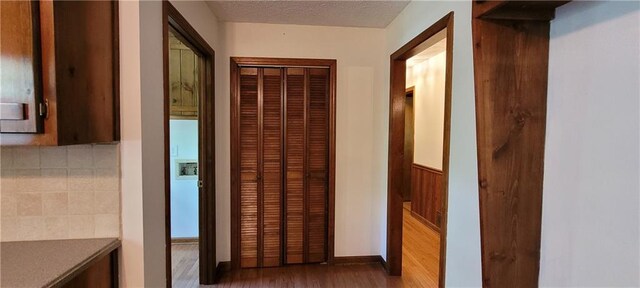 hallway with wood finished floors and a textured ceiling