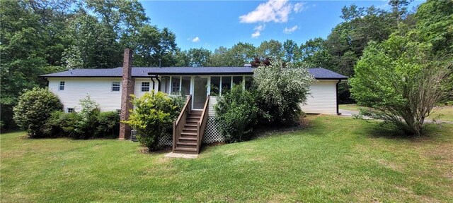 rear view of property featuring stairway, a lawn, a porch, and a chimney