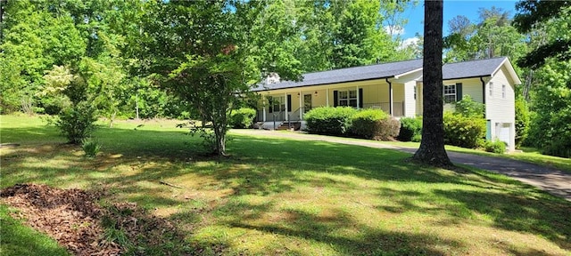 view of front of home featuring a front lawn, a porch, and driveway
