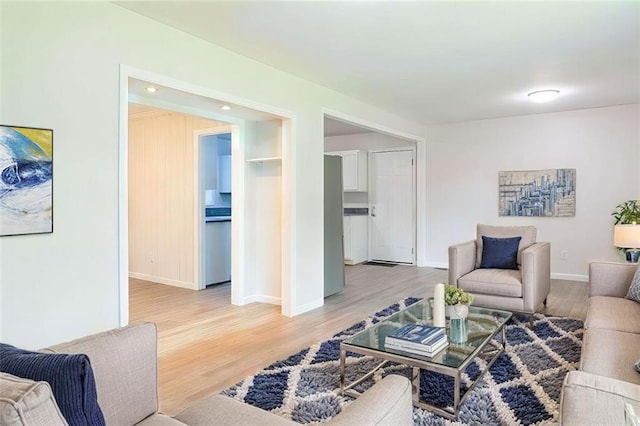 living area featuring light wood-style flooring and baseboards