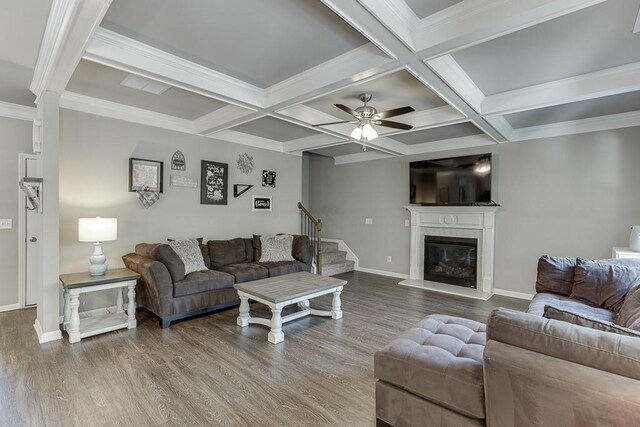 living room with baseboards, a ceiling fan, wood finished floors, and beamed ceiling