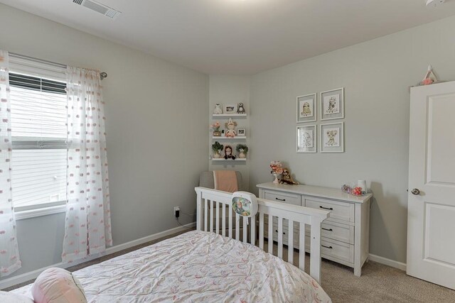 bedroom with baseboards, light carpet, and visible vents