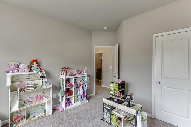 recreation room with baseboards and carpet flooring