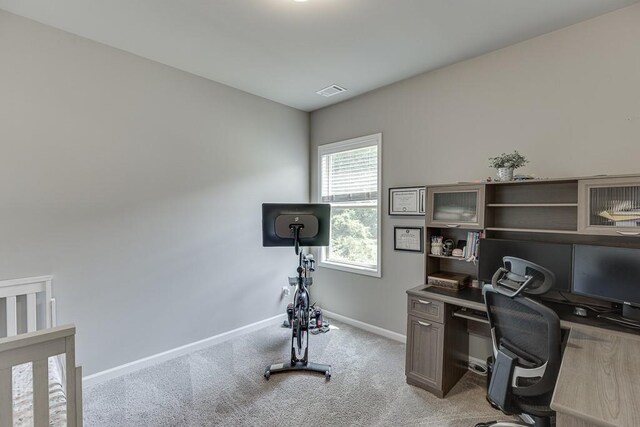 office area with baseboards, visible vents, and light carpet