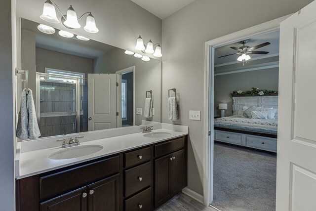 full bath featuring double vanity, a sink, connected bathroom, and baseboards