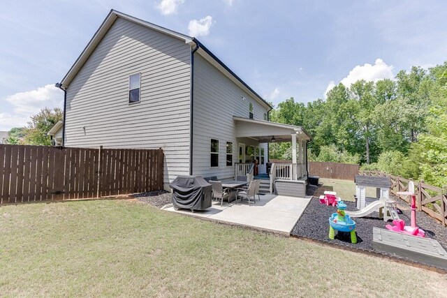 rear view of property with a fenced backyard, a patio, and a yard
