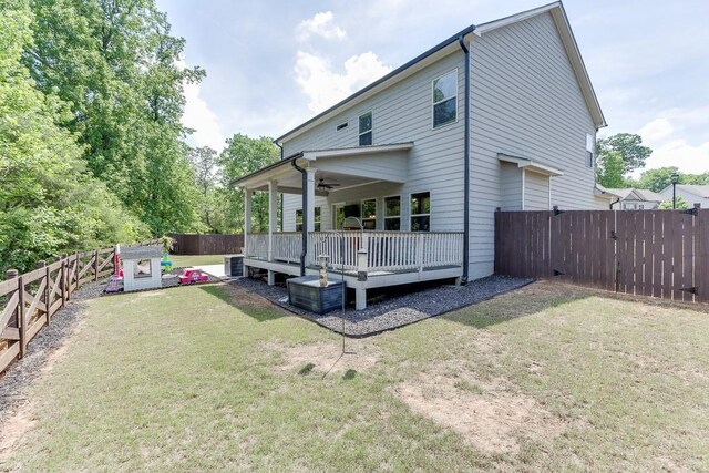 rear view of house featuring a fenced backyard, a wooden deck, ceiling fan, and a lawn